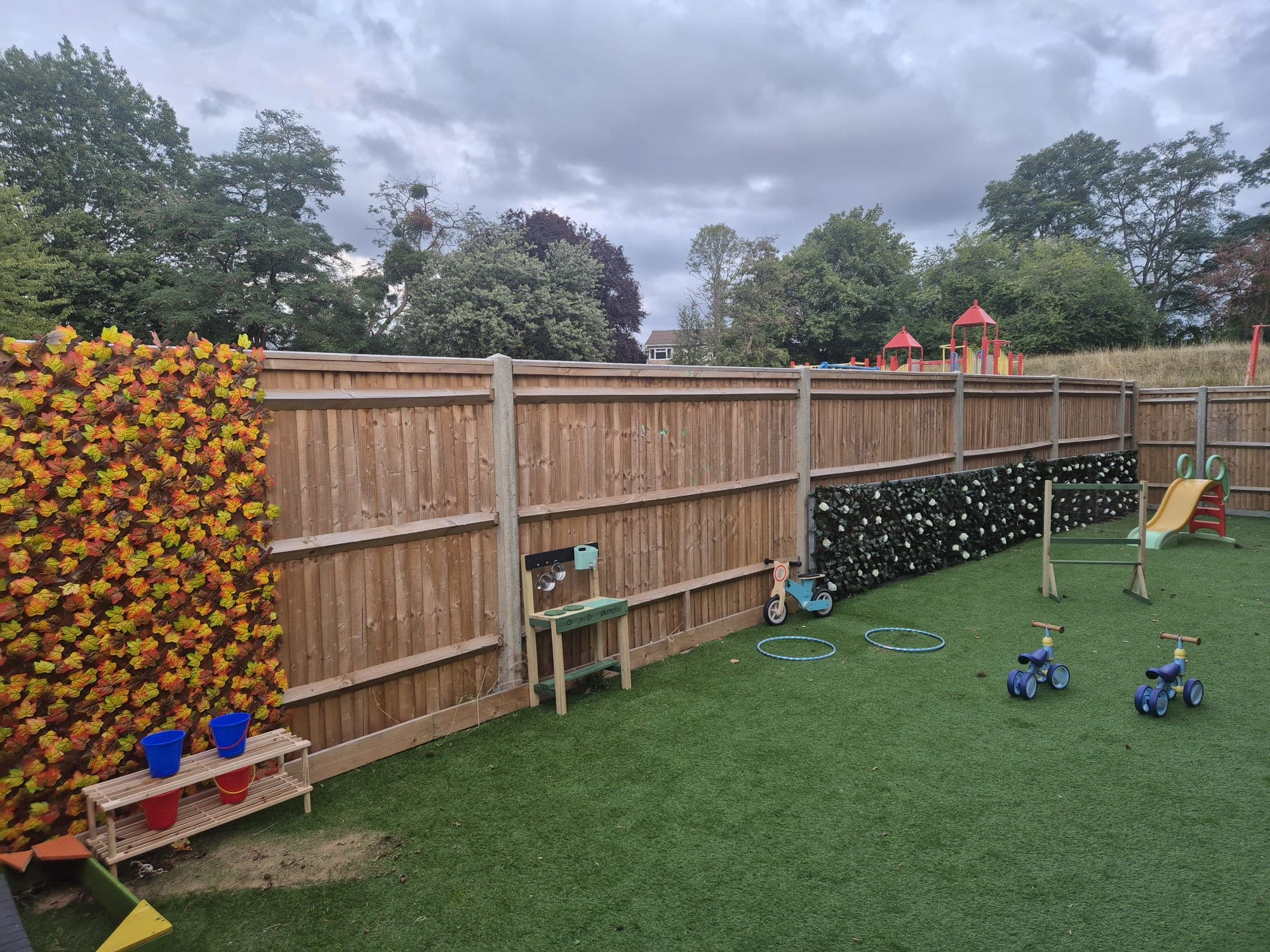 The Daisy Rose garden play area with trikes, a slide and outdoor activities.