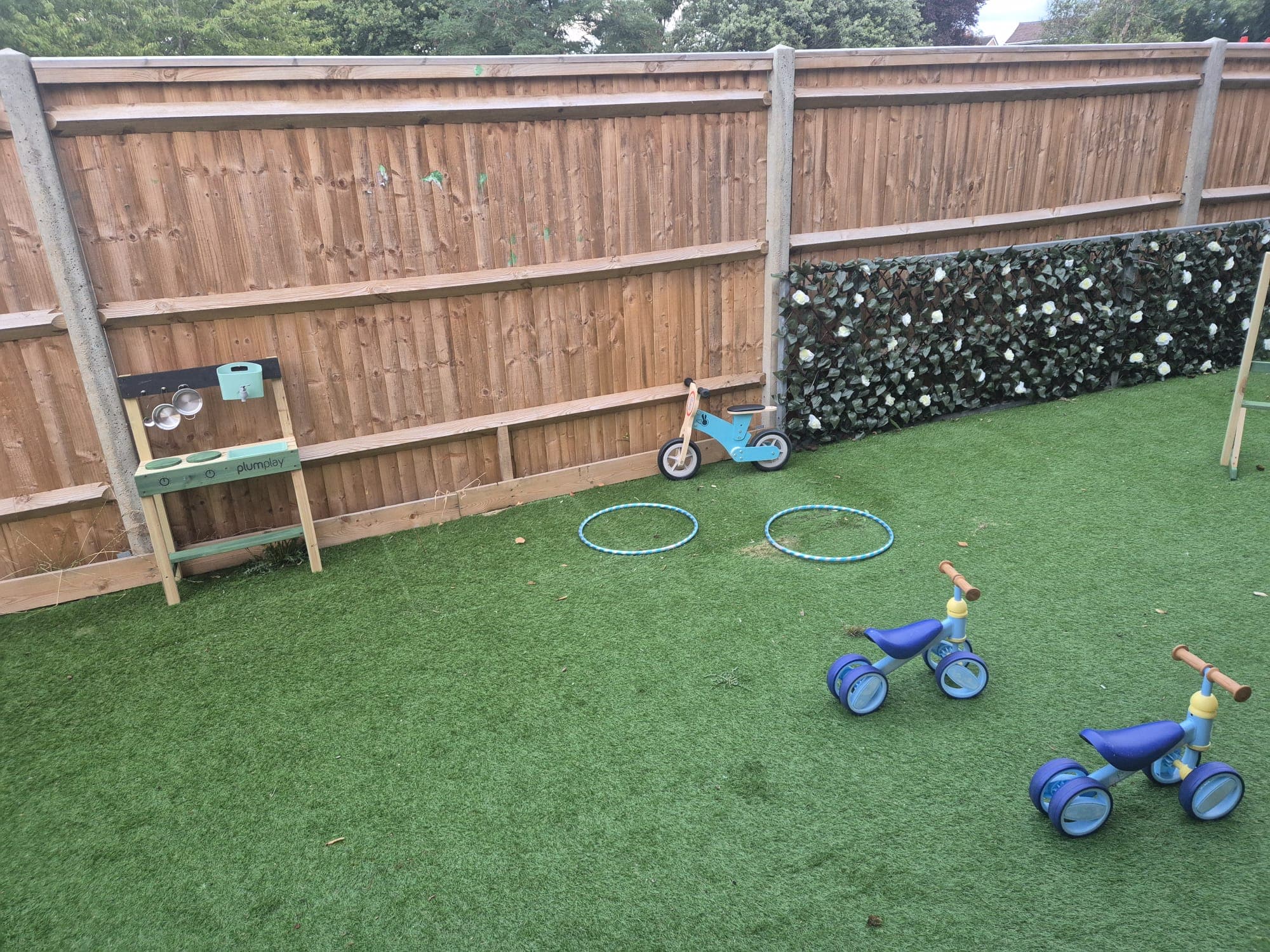 A bright outdoor play space with trikes and activity equipment at Daisy Rose Daycare.